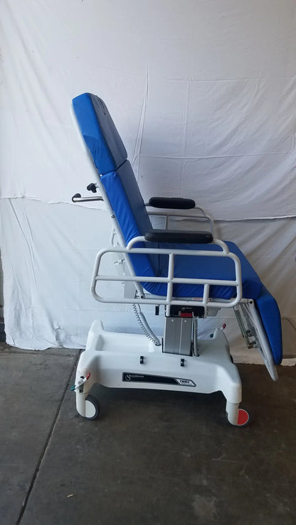 Blue padded TransMotion Medical TMM4 multi purpose stretcher chair with white metal frame and casters for medical use