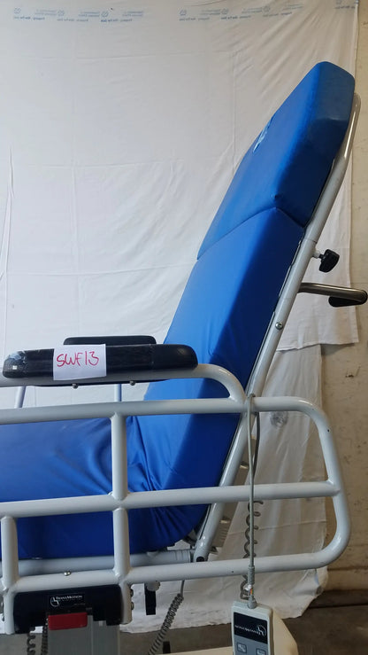 Blue padded TransMotion Medical TMM4 multi purpose stretcher chair with white metal frame and control panel