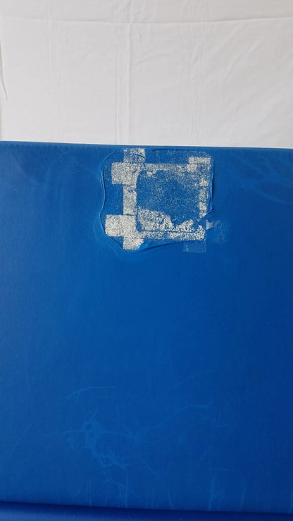 Blue plastic surface with white stencil design partially peeled on transmotion medical tmm4 multi purpose stretcher chair