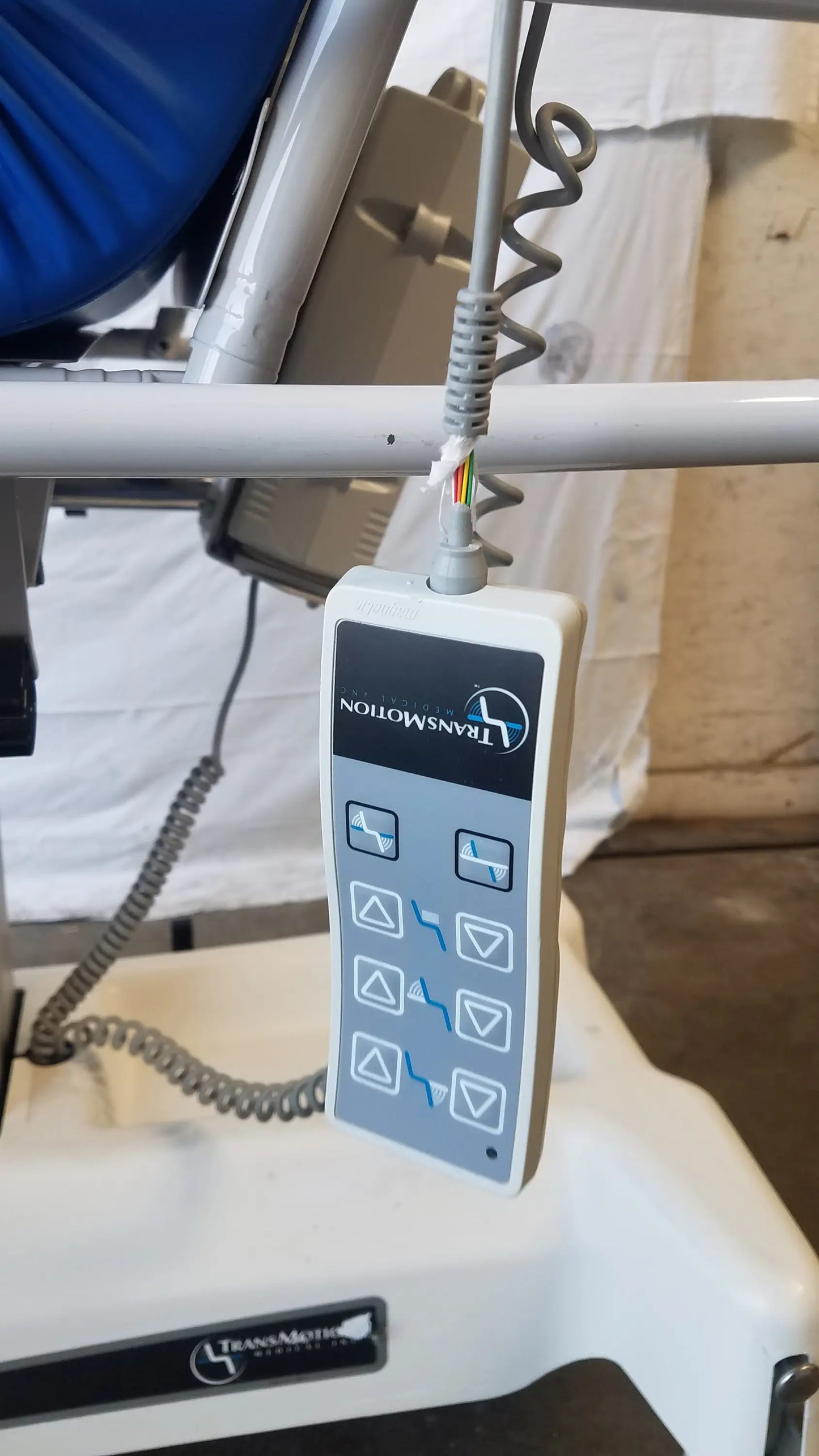White plastic control panel with gray buttons and blue icons on transmotion multi purpose stretcher chair
