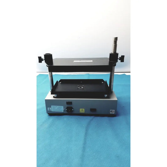 Black and silver industrial press machine with adjustable clamps and flat platform in tripath imaging multi-vial vortexer 30cr000106