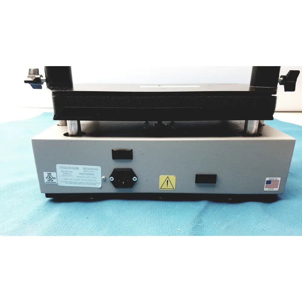 Gray metal industrial press with black top plate and silver legs in tripath imaging multi-vial vortexer 30cr000106