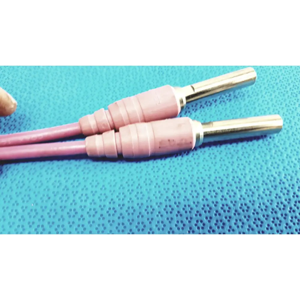 Pink insulated welding electrodes with metallic tips shown alongside trompeter pink video patch cord for broadcast use
