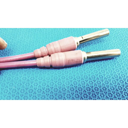 Pink insulated welding electrodes with metallic tips shown alongside trompeter pink video patch cord for broadcast use