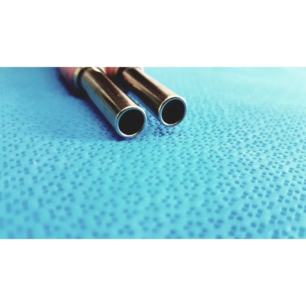 Two metallic cylindrical tubes with reflective silver finish lie parallel on blue surface of trompeter pink video patch cord
