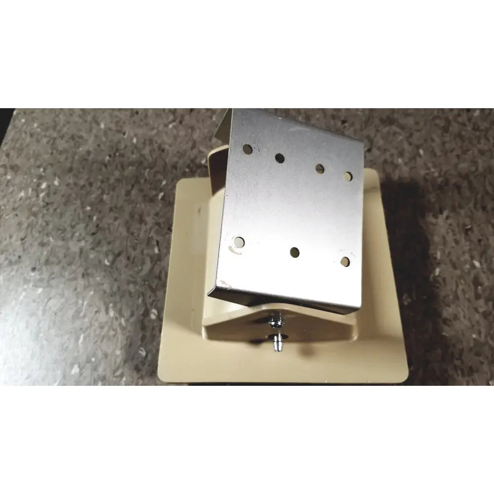 Silver metal bracket with multiple holes and central screw mounted on beige base of tycos lifetime certified sphygmomanomet