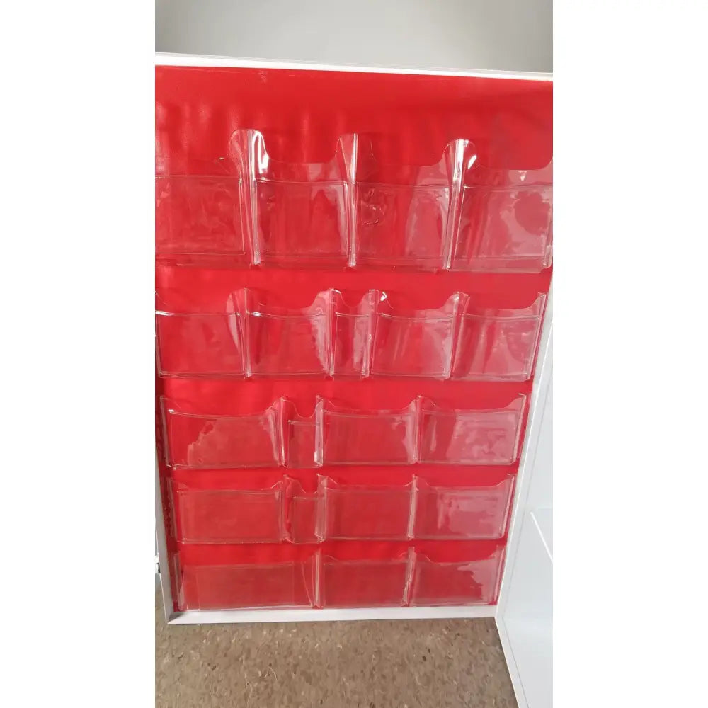 Red plastic organizer with clear pockets arranged in a grid for the uline h-5951 3-shelf aid cabinet
