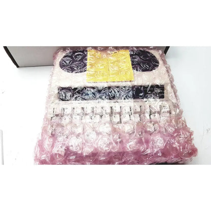 Vintage pink and white ultratec superprint telephone printer tty with black keys wrapped in protective bubble wrap