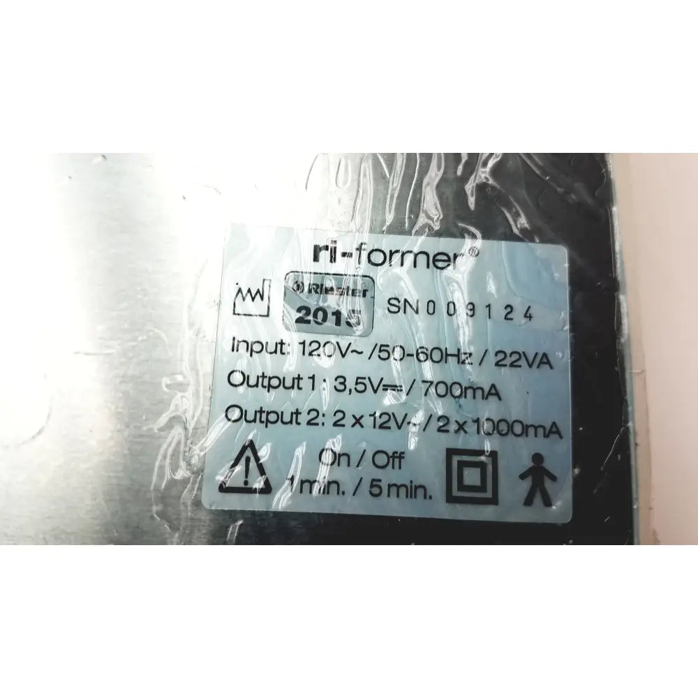 Silver-colored ri-former power supply unit with white label showing specifications for ulvac air compressor unit model