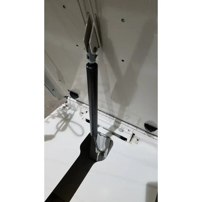 Black gas spring with metallic end caps attached to white cabinet on umf 4070 power table with hand control for reuse medical