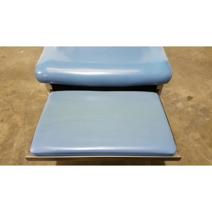Umf 4070 power table with hand control featuring light blue padded vinyl seat and matching footrest on metal frames medical equipment