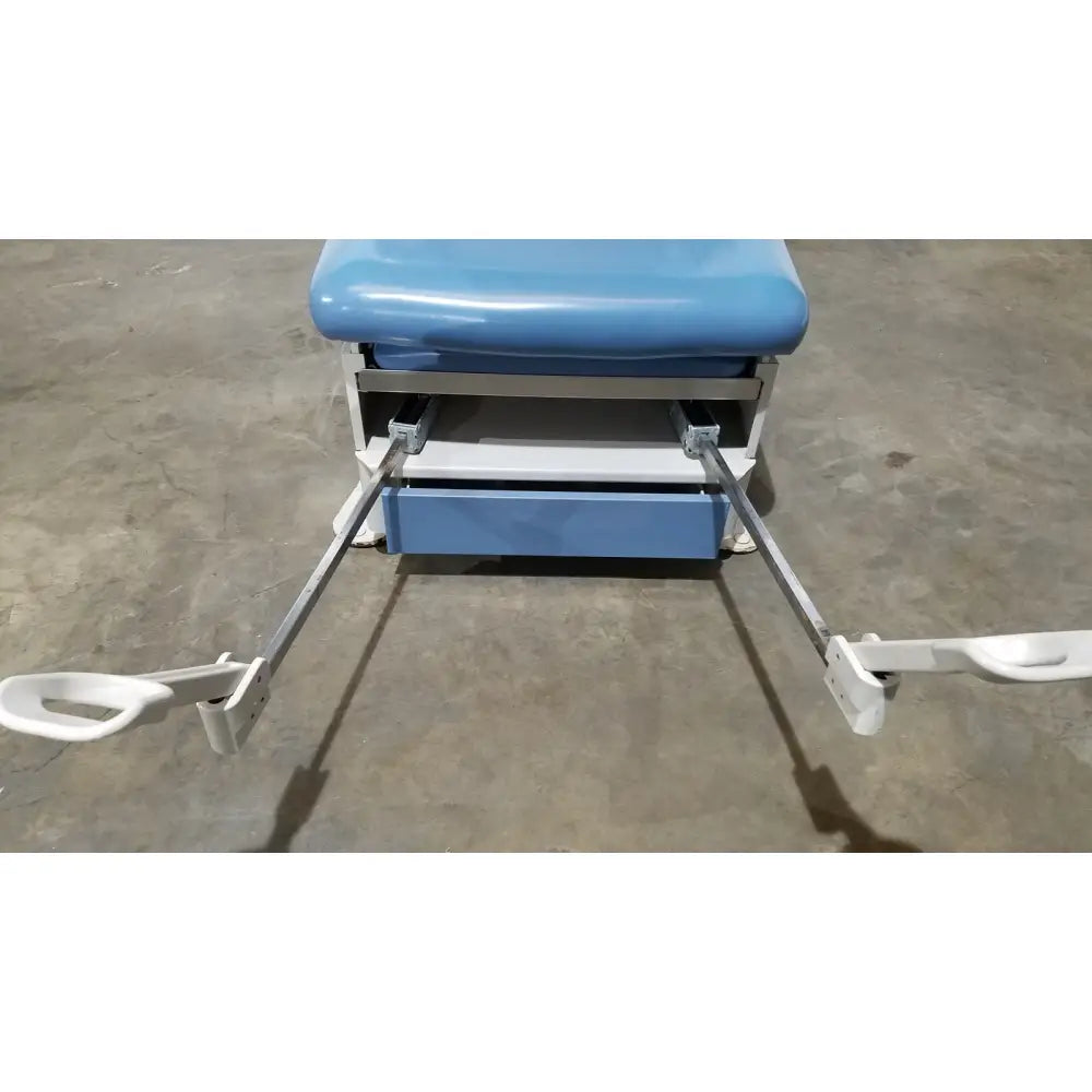 Blue padded UMF 4070 power table with white metal frame and hand control for reuse medical examinations
