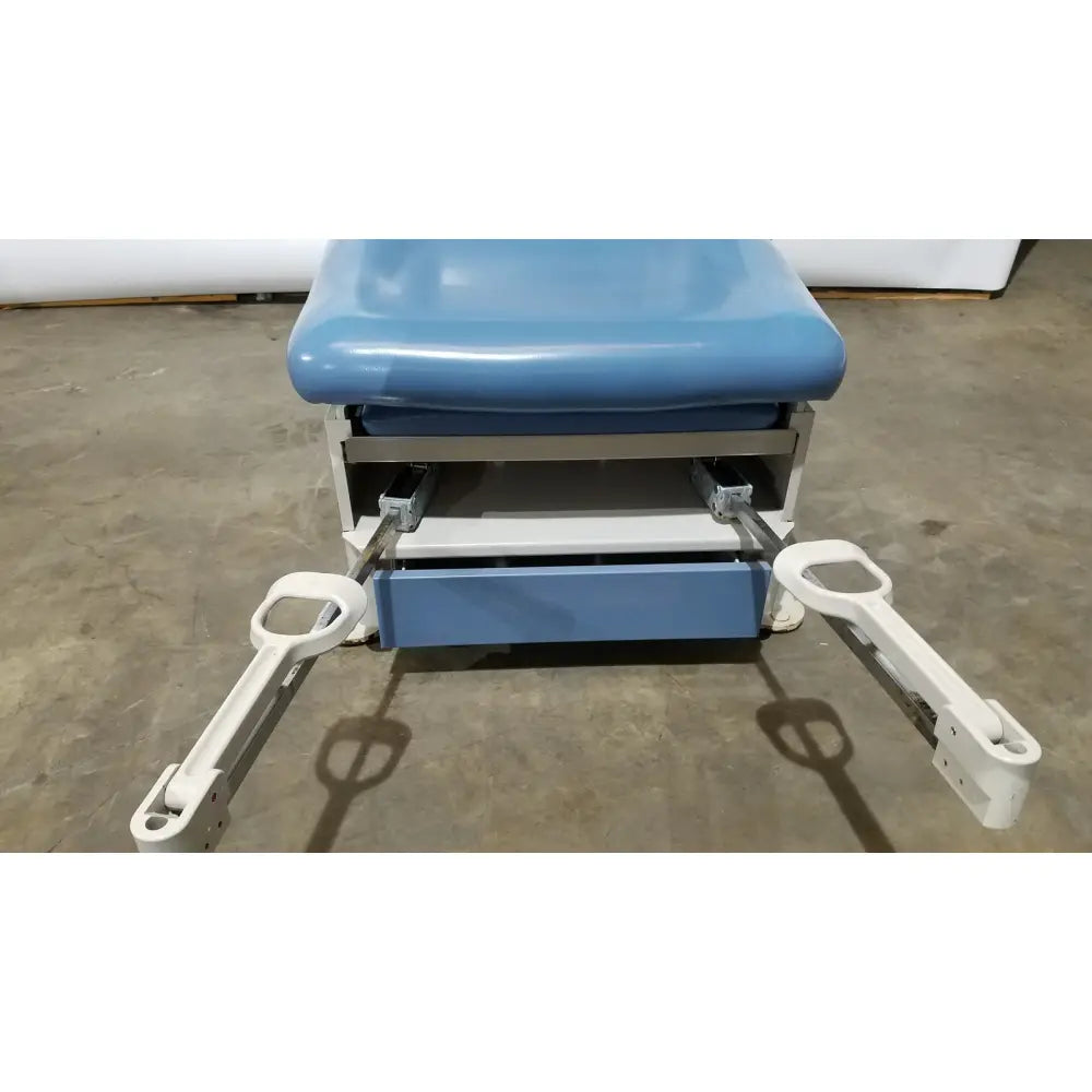 Blue padded UMF 4070 power table with white metal frame adjustable footrests and hand control for reuse medical settings