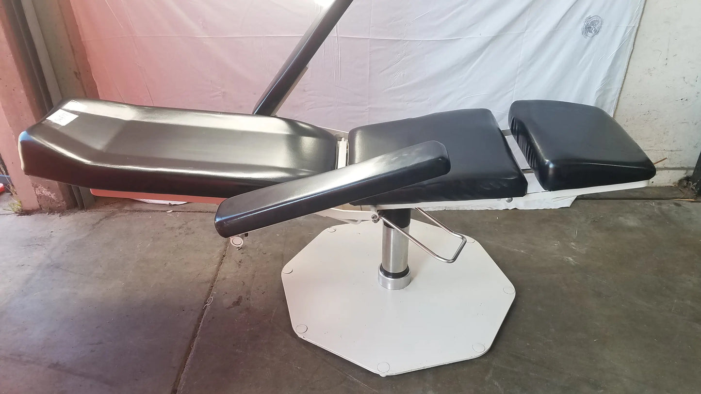 Black padded adjustable phlebotomy chair with white octagonal base and chrome metal frame for medical use