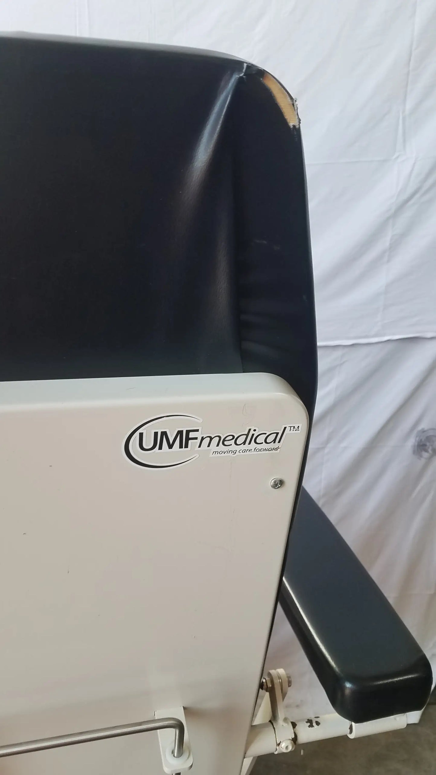 Black vinyl-covered adjustable phlebotomy chair with white metal frame and umfmedical branding side view