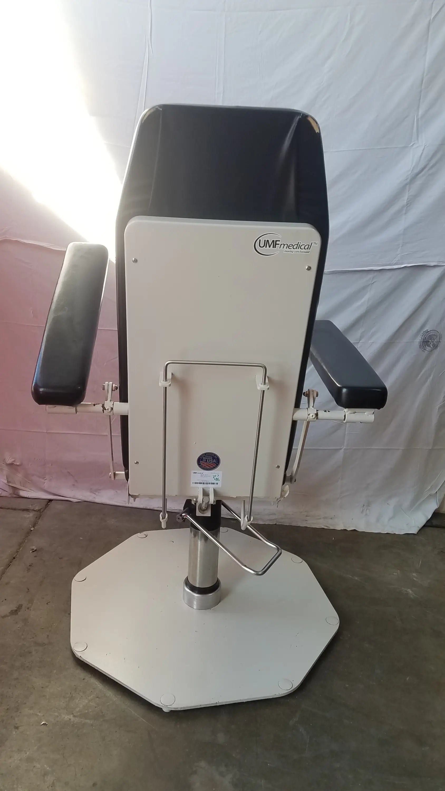 Black and white UMF Medical 8675 adjustable phlebotomy chair with adjustable armrests and hexagonal base