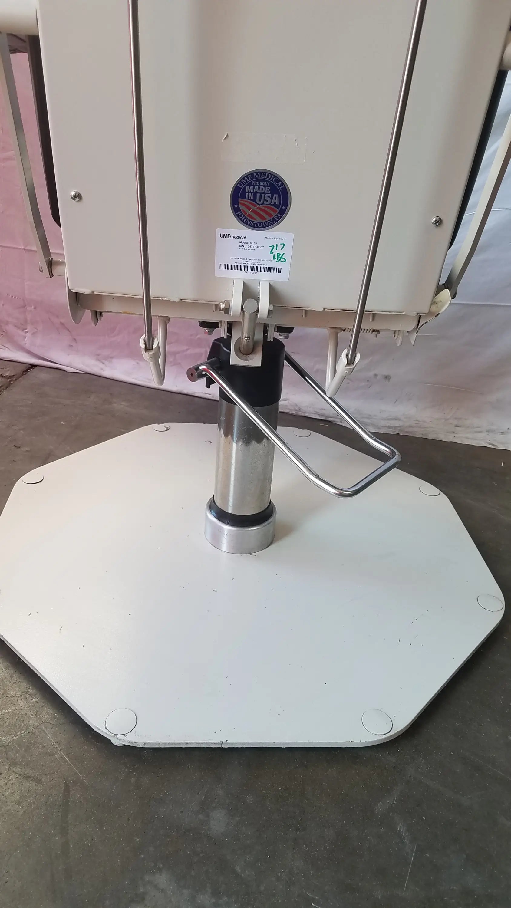 White octagonal base with chrome plated column and black adjustment mechanism on umf medical 8675 adjustable phlebotomy chair