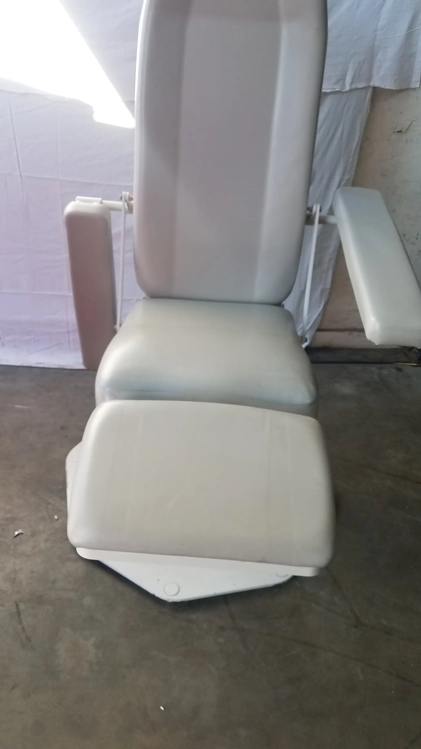 Beige upholstered UMF Medical 8675 adjustable phlebotomy chair with armrests and matching footrest for medical use