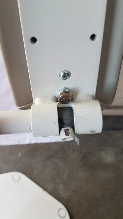 White plastic pipe connector with metal bolt securing the back of umf medical 8675 adjustable phlebotomy chair panel