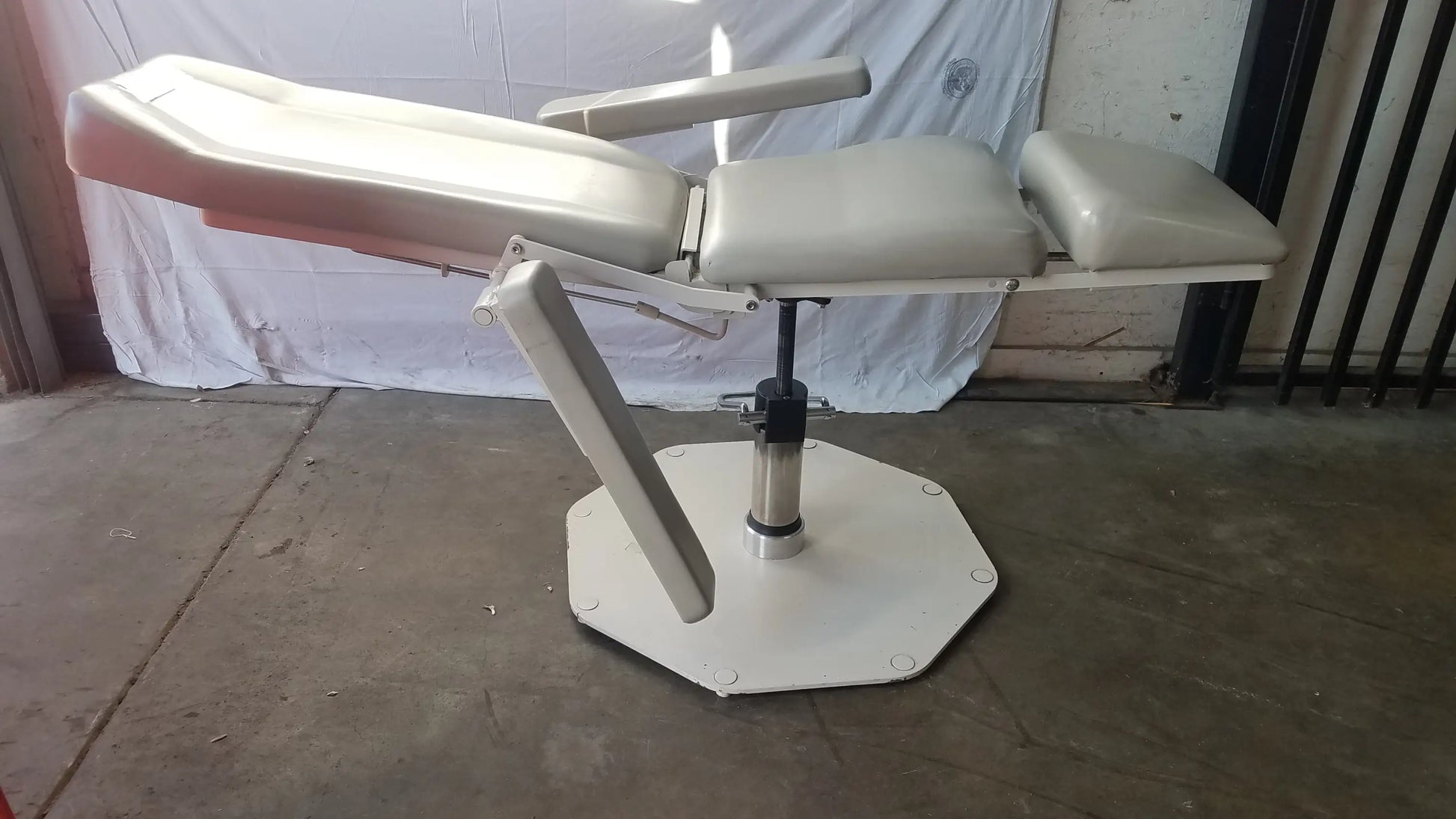 Adjustable white phlebotomy chair UMF Medical 8675 with padded sections and hexagonal base for medical examinations