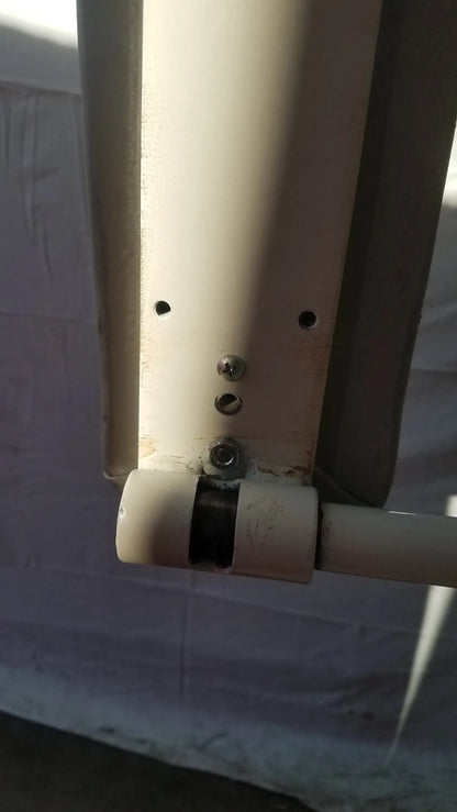 White plastic pipe joint with metal screws and black rubber seal on uml medical 8675 adjustable phlebotomy chair