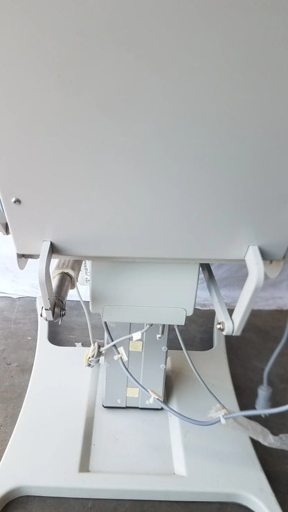 Gray metallic power exam phlebotomy chair with attached cables from umf medical equipment model 29ze 8677 s/n 93358