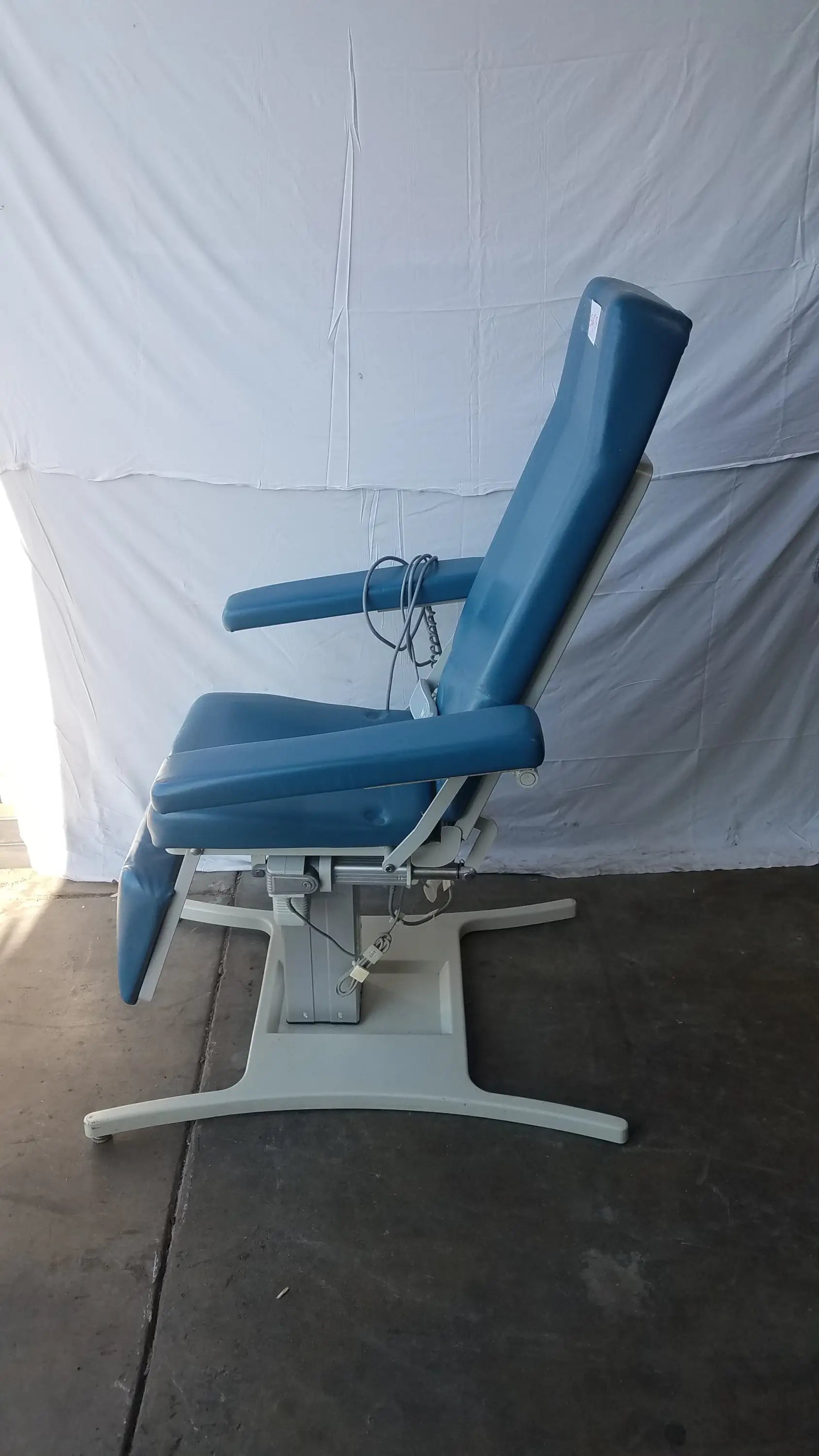 Blue upholstered power exam phlebotomy chair with white metal base by umf medical equipment model 29ze 8677