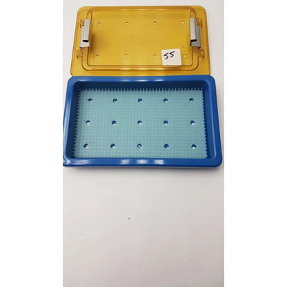 Blue and yellow plastic universal instrument sterilization container with finger matt and circular indentations tray