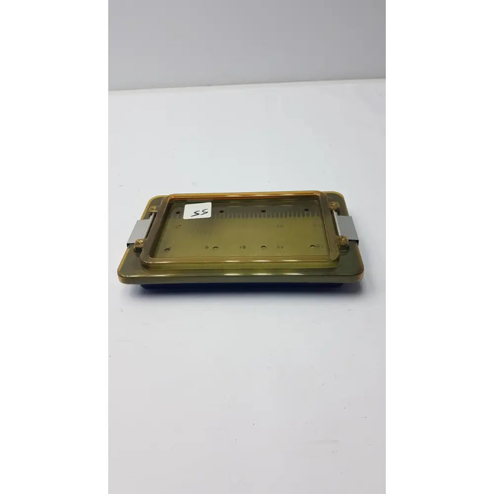 Translucent amber plastic universal instrument sterilization container with metallic side clamps for secure closure