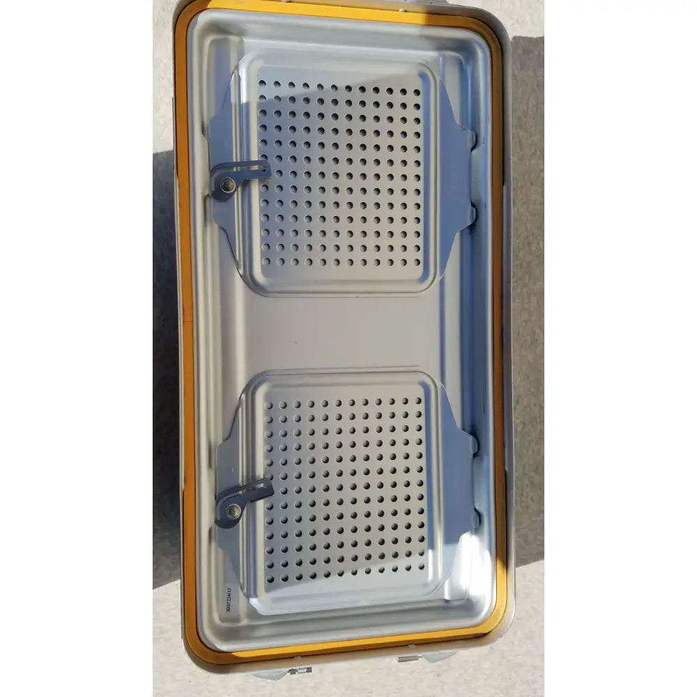 Silver metal baking tray with two perforated compartments and yellow edge for v.mueller dincd3-5lt genesis carefusion sterilization container