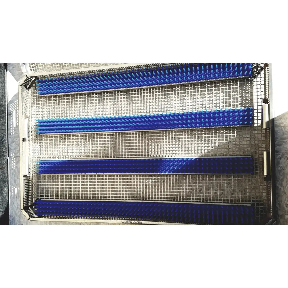 Blue bristle cleaning brushes arranged in a metal tray inside a vm mueller genesis carefusion sterilization container 5 inch deep