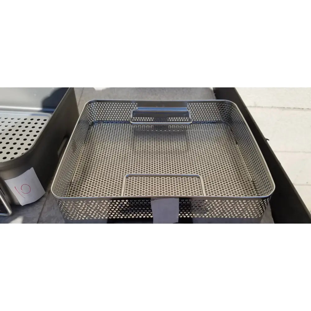Stainless steel perforated rectangular basket with integrated handle and base frame for genesis carefusion sterilization container