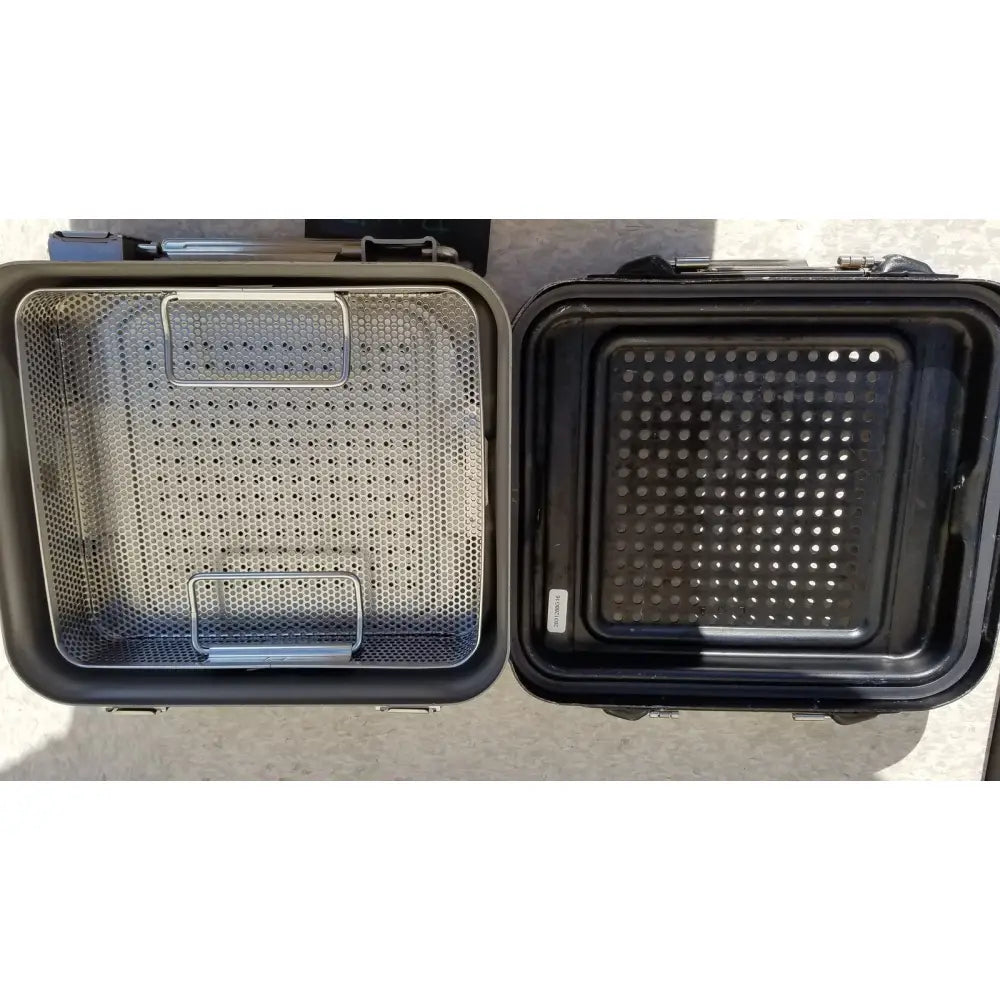 Black and silver stainless steel mesh baking trays with reinforced handles for oven use in genesis carefusion sterilization container