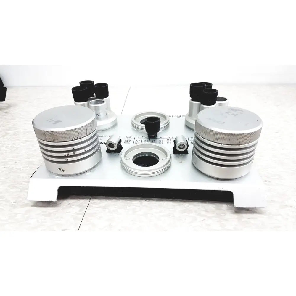 Silver metallic cylindrical components with ribbed texture and black-tipped optical attachments of vaisala hmk15 humidity calibrator