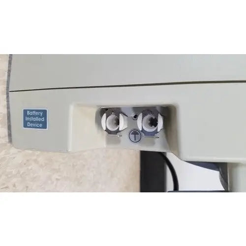 Beige plastic back side of venaflow elite aircast dvt vascular pump system with two battery compartments and blue label