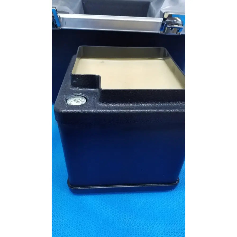 Black rectangular Verathon BladderScan tissue equivalent bladder phantom with beige interior and silver cap and latch mechanism