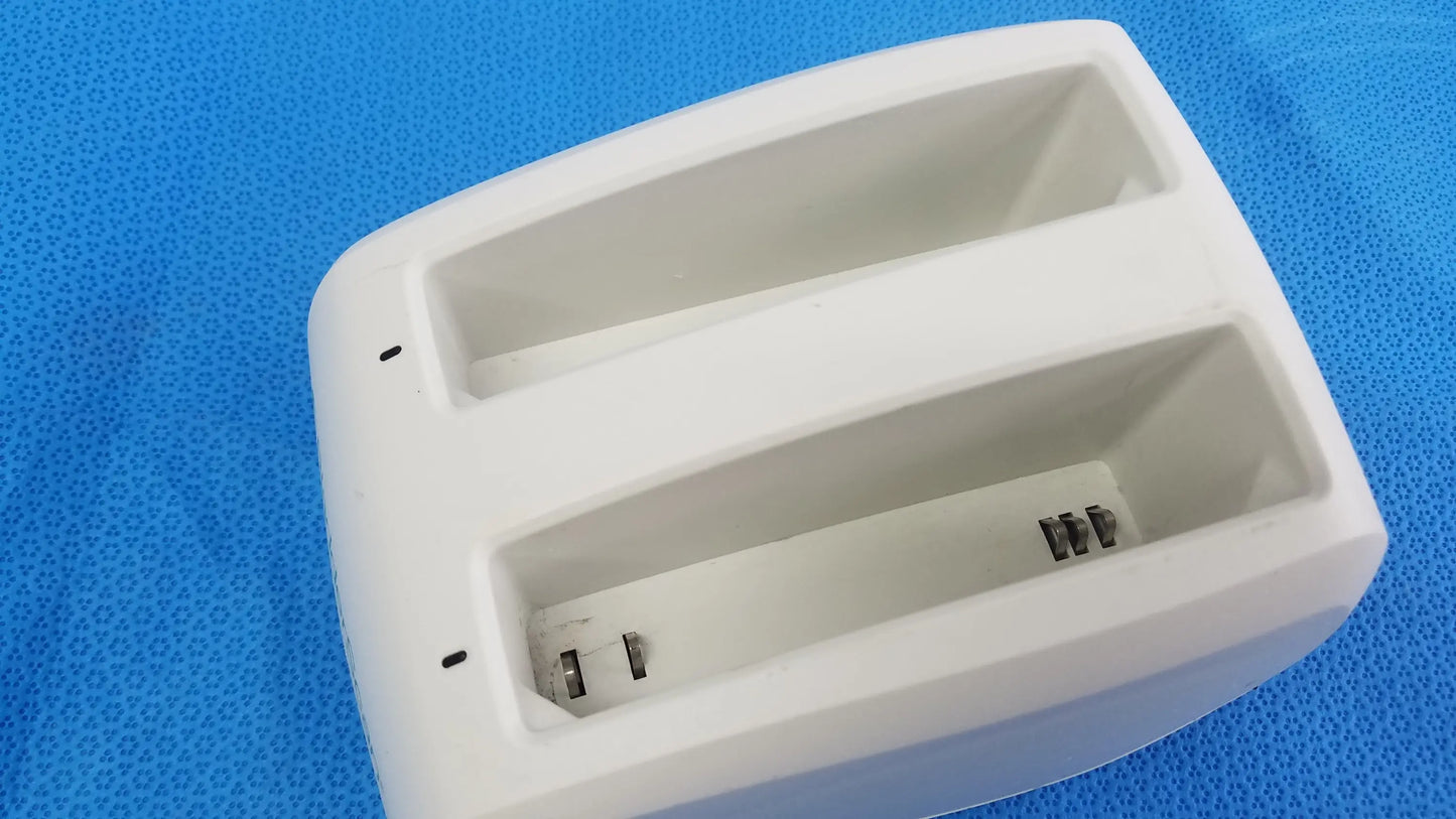 White plastic dual-slot battery charger with metallic contacts compatible verathon bladderscan model P/N 0570-0193