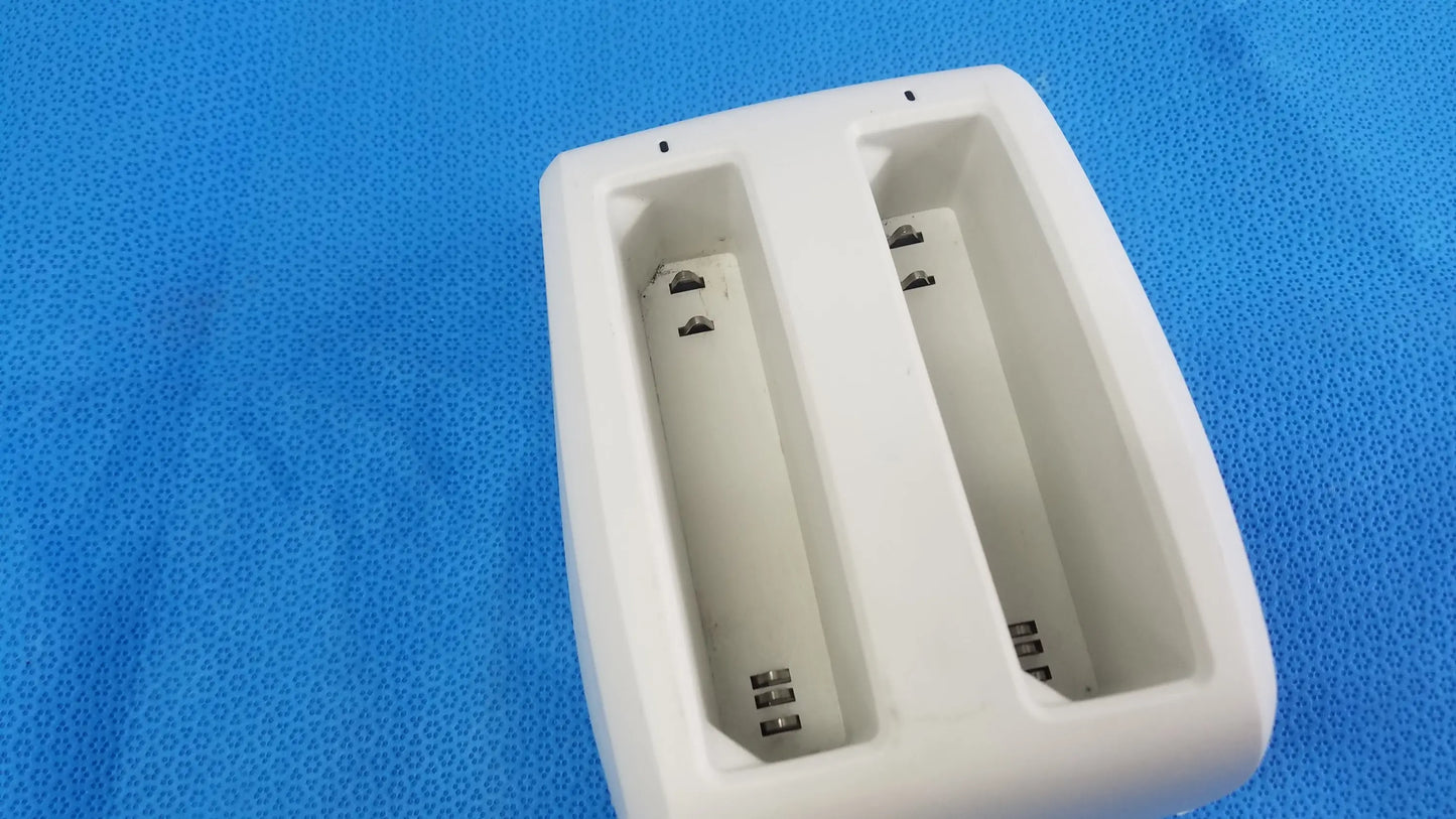 White plastic dual-slot battery charger with metallic contacts for compatible verathon bladderscan devices p n 0570-0193