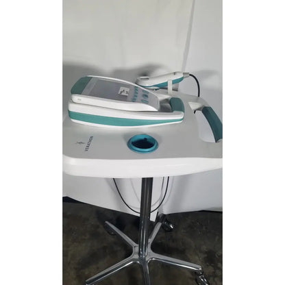 White and teal Verathon BladderScan stand medical device with handheld probe resting on its console for bladder assessment