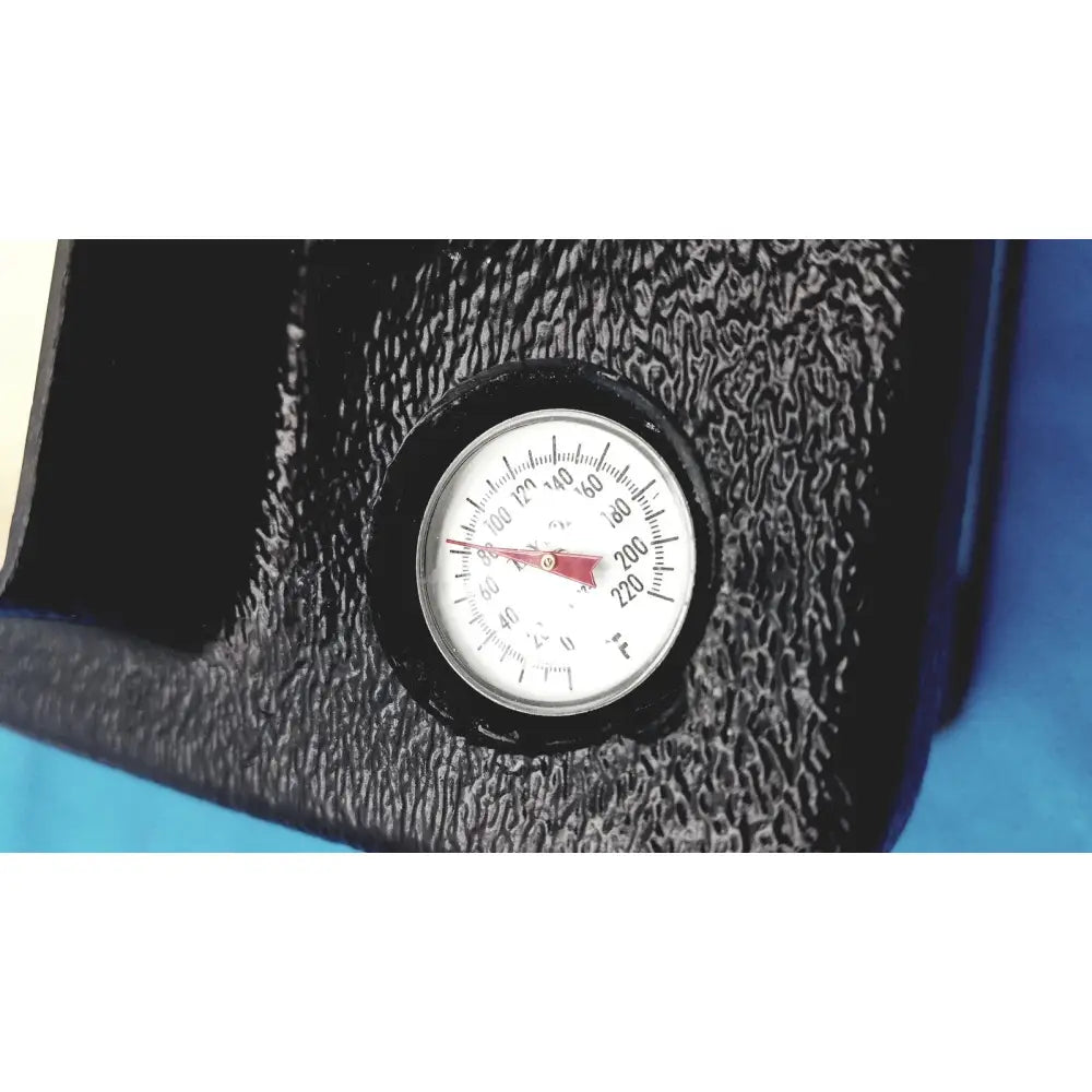 Circular temperature gauge with white face black markings and red needle on textured black surface of verathon bladderscan tissue equivalent bladder phantom