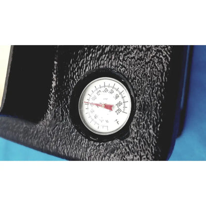 Circular temperature gauge with white face black markings and red needle on textured black surface of verathon bladderscan tissue equivalent bladder phantom