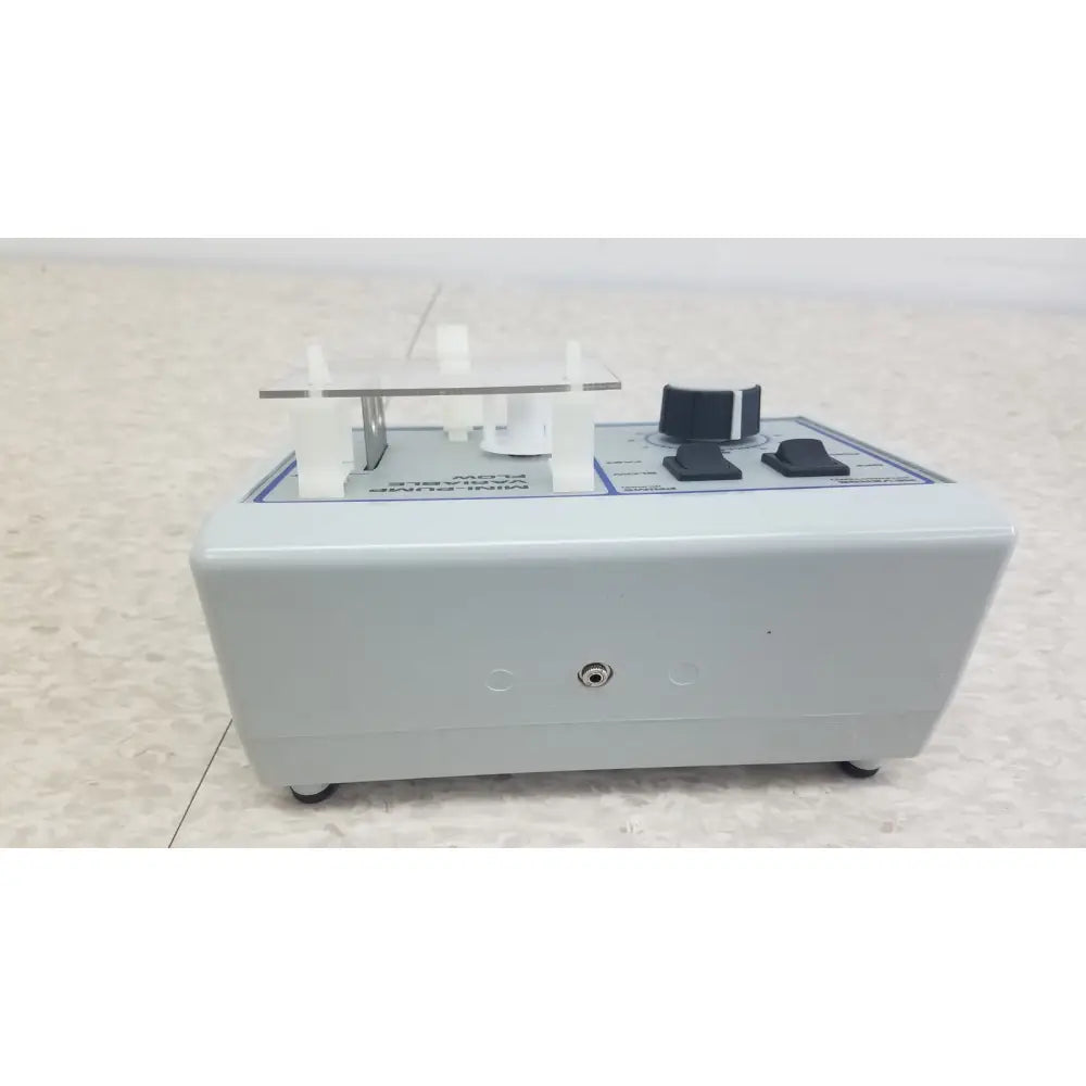 Gray plastic mini pump with black knobs and clear acrylic holder for clinical laboratory diagnostic Verities Analyzer