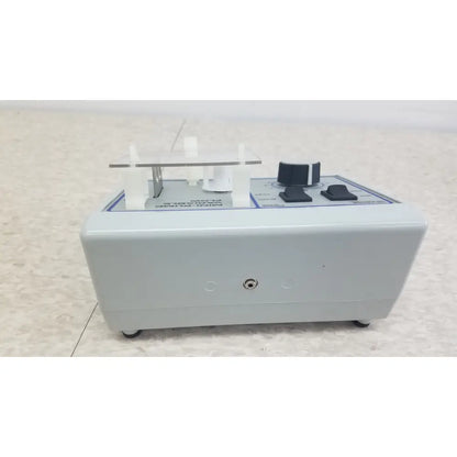 Gray plastic mini pump with black knobs and clear acrylic holder for clinical laboratory diagnostic Verities Analyzer