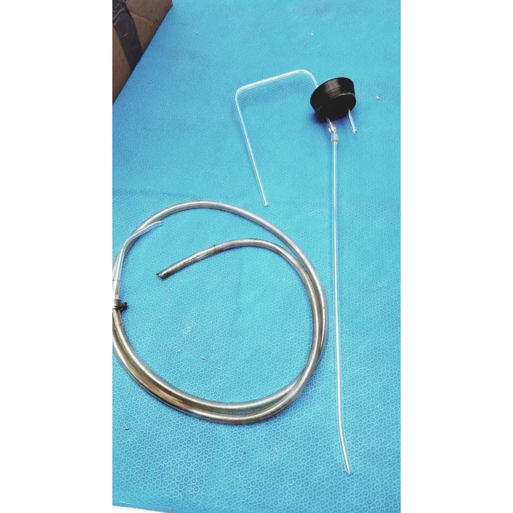 Silver-colored metal tubing with black circular component and clear plastic connectors alongside a vintage 9-inch clear glass bottle with embossed base