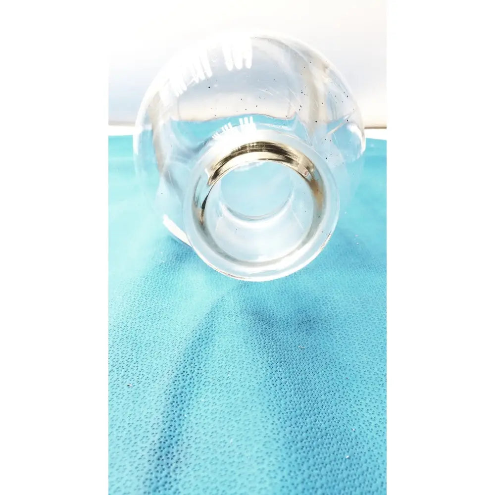 Vintage 9 inch clear glass bottle with embossed base and metallic silver rim, a timeless decorative piece