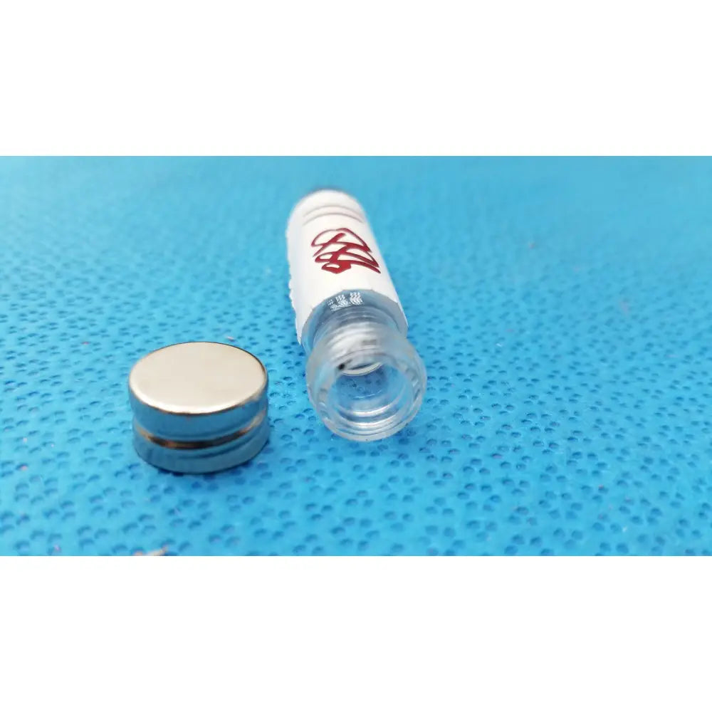 Vintage johnson era dental floss in a white cylindrical tube with red logo, clear cap, and silver metallic lid in glass bottle
