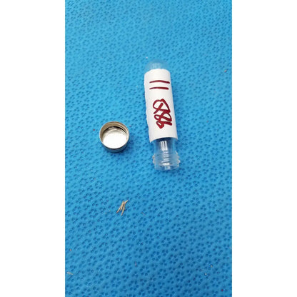 Vintage johnson era dental floss in a clear glass vial with a white label marked in red ink and silver metal cap