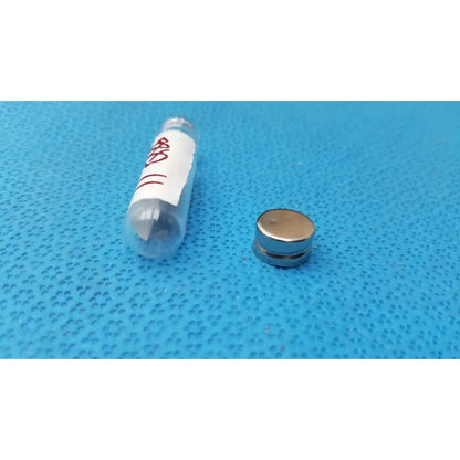 A small round metallic neodymium magnet with a shiny silver finish and two layers used with vintage johnson era dental floss