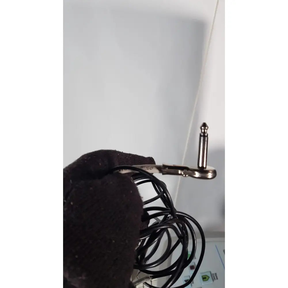 Black coiled audio cable with silver 6.35mm stereo plug held by gloved hand for volcano s5 imaging operator’s manual reuse medical