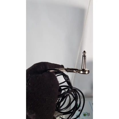 Black coiled audio cable with silver 6.35mm stereo plug held by gloved hand for volcano s5 imaging operator’s manual reuse medical